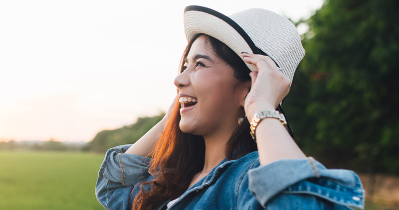 A woman wearing a hat, in a field.