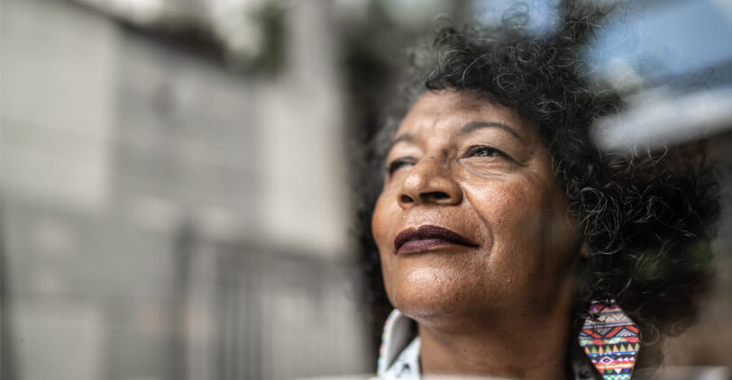 Hopeful woman looking out window