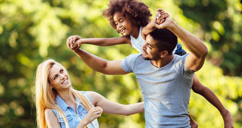 A happy family, outside on a  sunny day.