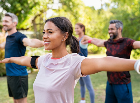 A group of middle-aged women and men exercising outdoors.