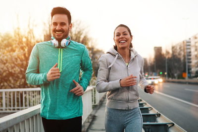 man and woman jogging on city street