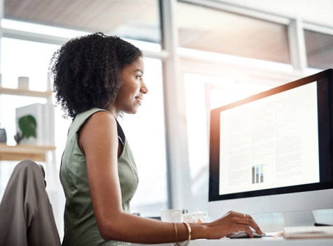 Woman at her desk looking at a computer screen