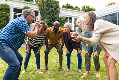 “Senior man explaining rugby rules to senior
friends in the backyard.