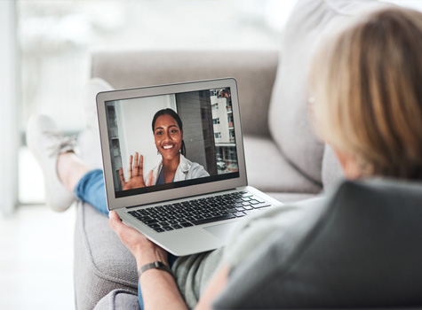 A woman attending a virtual doctor's visit on a laptop