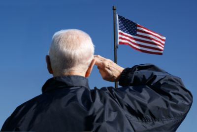 Veteran saluting American flag