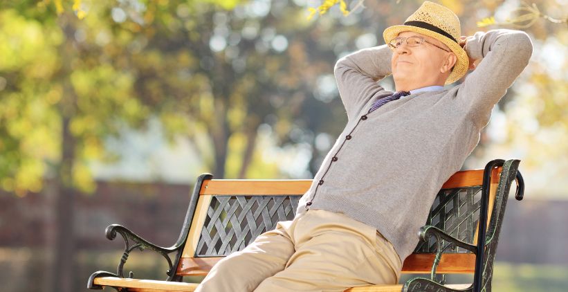 Elderly gentleman sitting on a bench in park