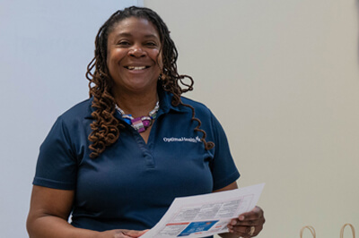 Female in a blue polo receiving a certificate.