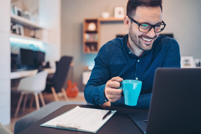 Man working on laptop drinking coffee