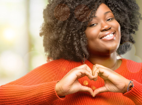 A happy woman making a heart shape with her hands