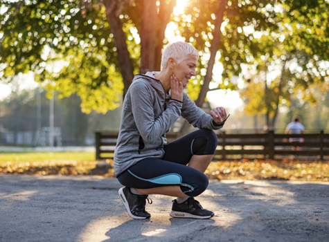 A senior woman exercising and checking her pulse.