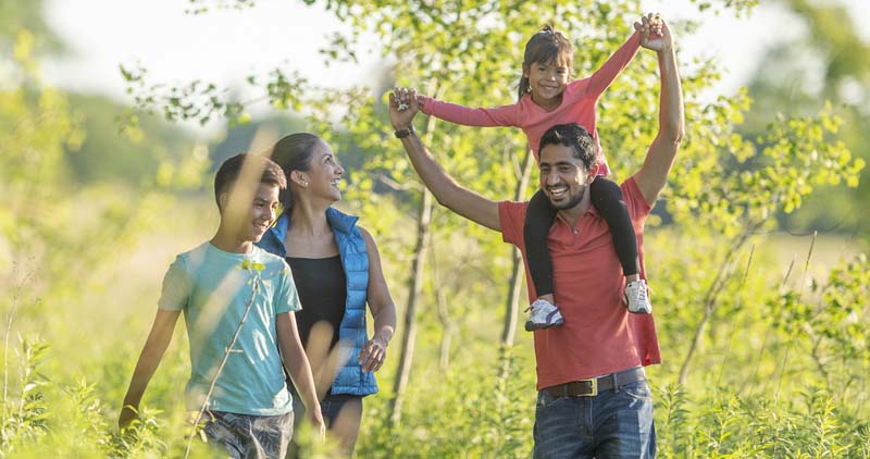 A family taking a nature walk on a beautiful day.