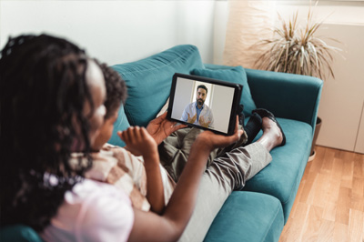 A mom helping her young daughter attend a virtual doctor's visit.