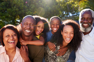 A happy multi-generational family outside on a sunny day.